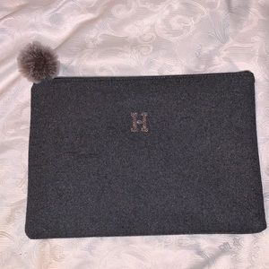 Gray bag with the Letter H, has Pom Pom on zipper